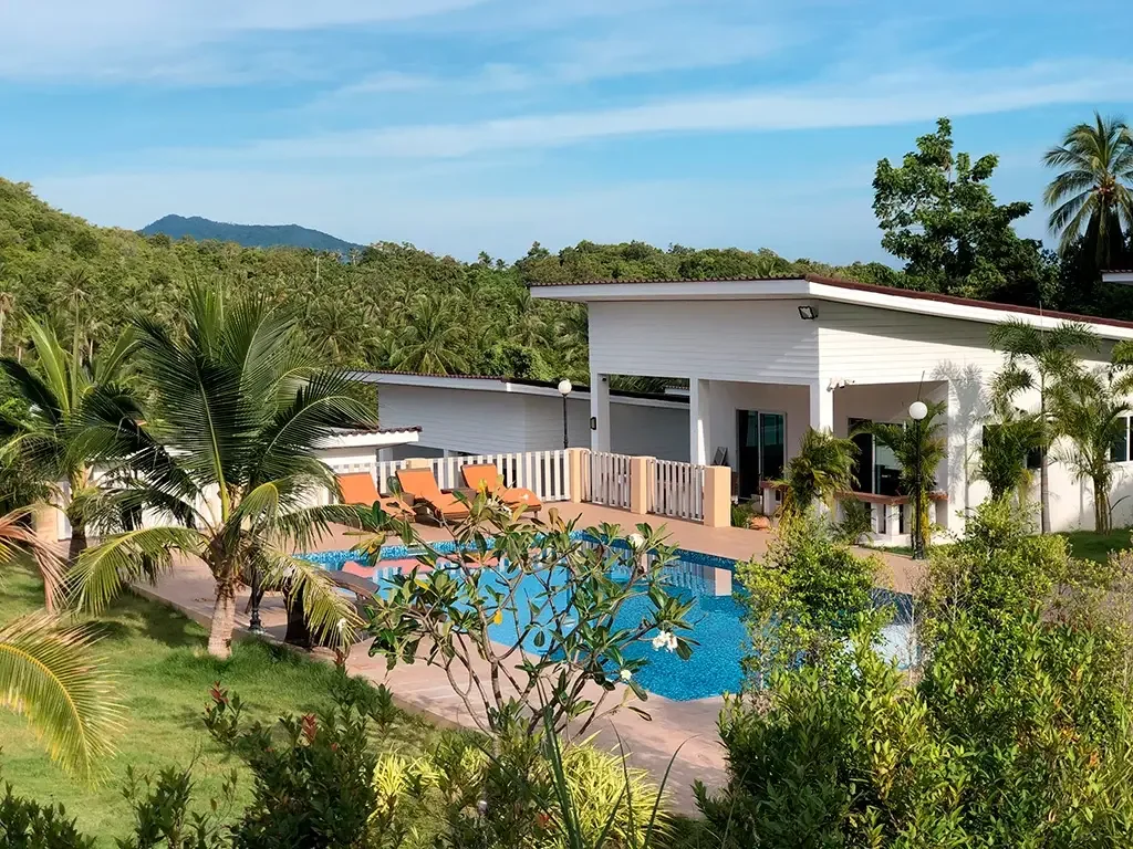 The swimming pool and villas nestled into the green hillside