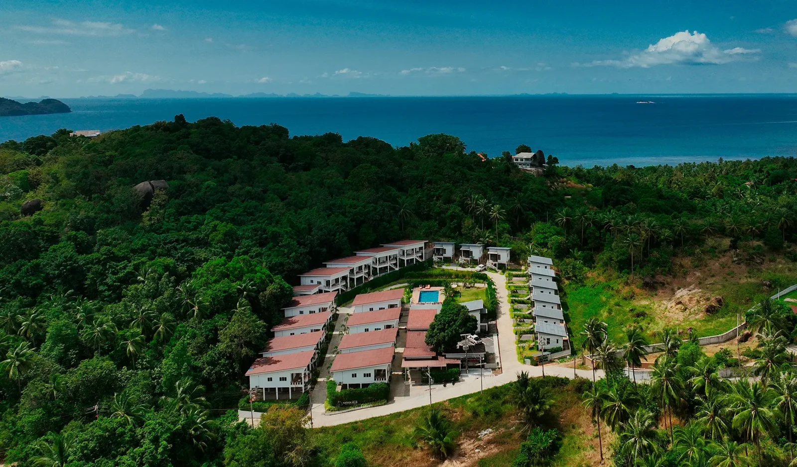 An aerial view of Naiwok Hills, surrounded by tropical greenery with the sea beyond